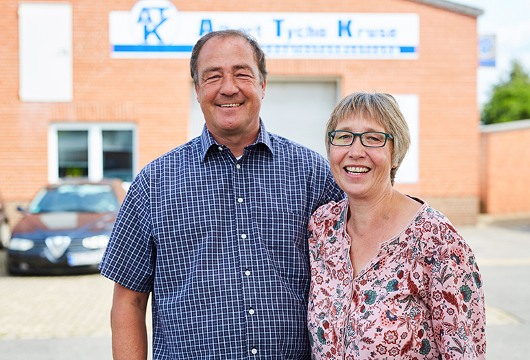 Familiengeführte KFZ-Meisterwerkstatt Albert Tycho Kruse in Minden Zwei lächelnde Personen stehen vor einem Werkstattgebäude