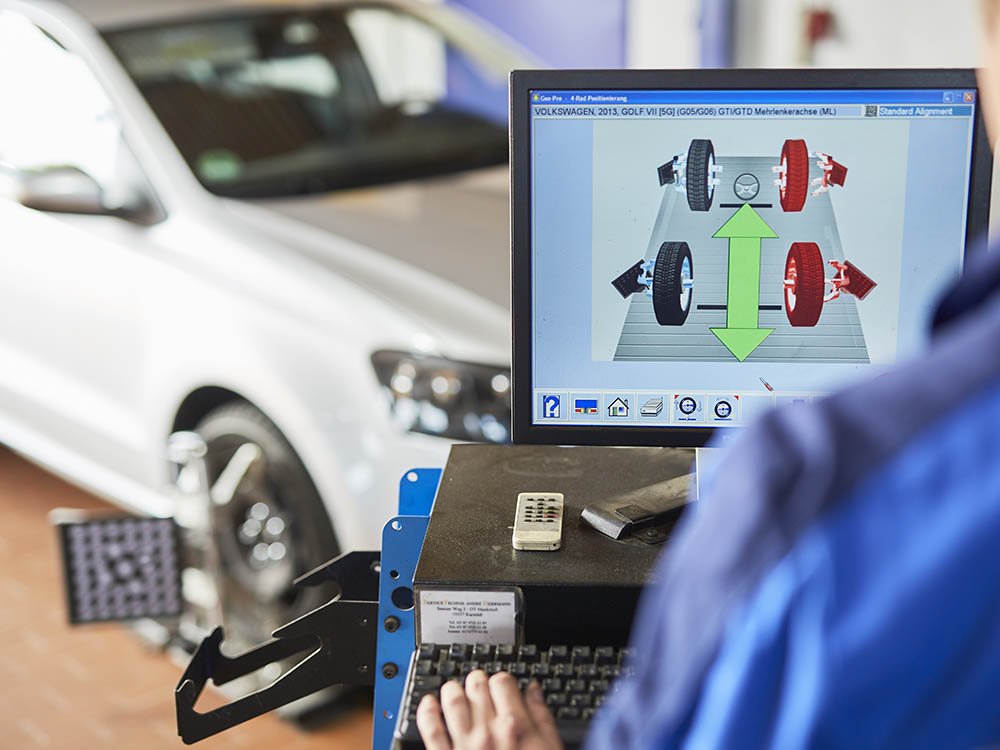 Achsvermessung und Fahrwerksservice bei Albert Tycho Kruse in Minden Bedienung eines Achsvermessungssystems mit Monitor und angeschlossenem Fahrzeug