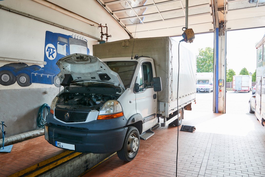Service und Reparatur für Nutzfahrzeuge bei Albert Tycho Kruse in Minden Nutzfahrzeug mit geöffnetem Motorraum steht in einer Werkstatt
